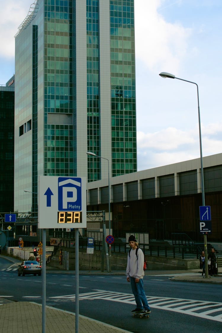 A Man Riding A Skateboard On The City Street