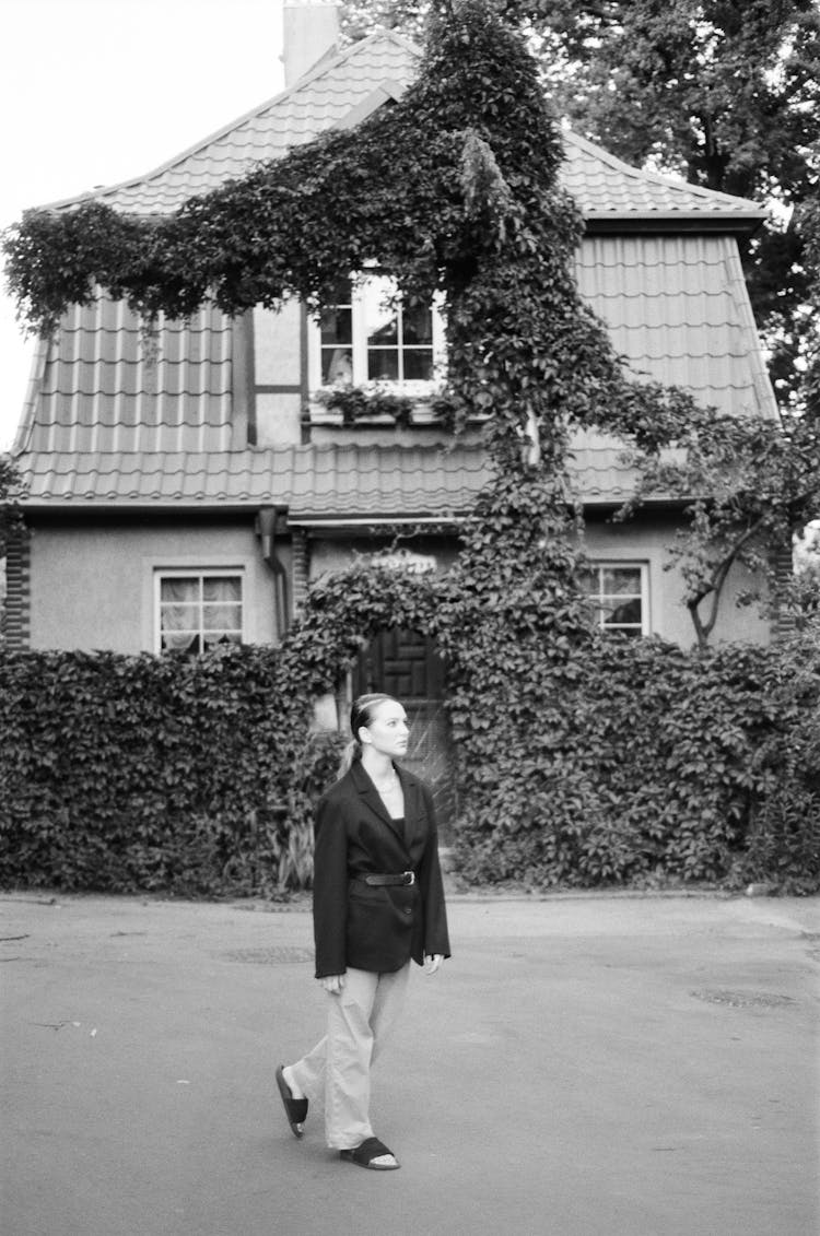 Woman In Blazer Walking Near A House