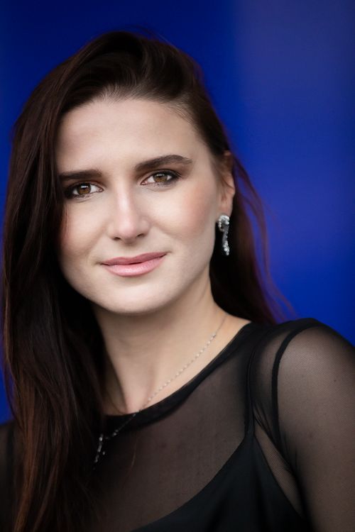 Free Portrait of a woman with long dark hair against a vibrant blue background. Stock Photo