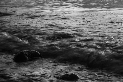 Free Moody black and white seascape capturing waves crashing over rocks, emphasizing motion. Stock Photo
