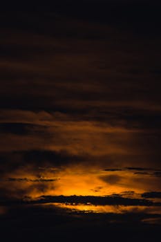 Captivating photo of a dramatic cloudy sky with an orange glow at sunset.