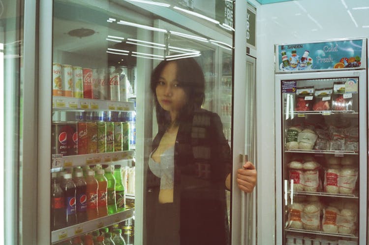 A Woman Holding A Refrigerator Door