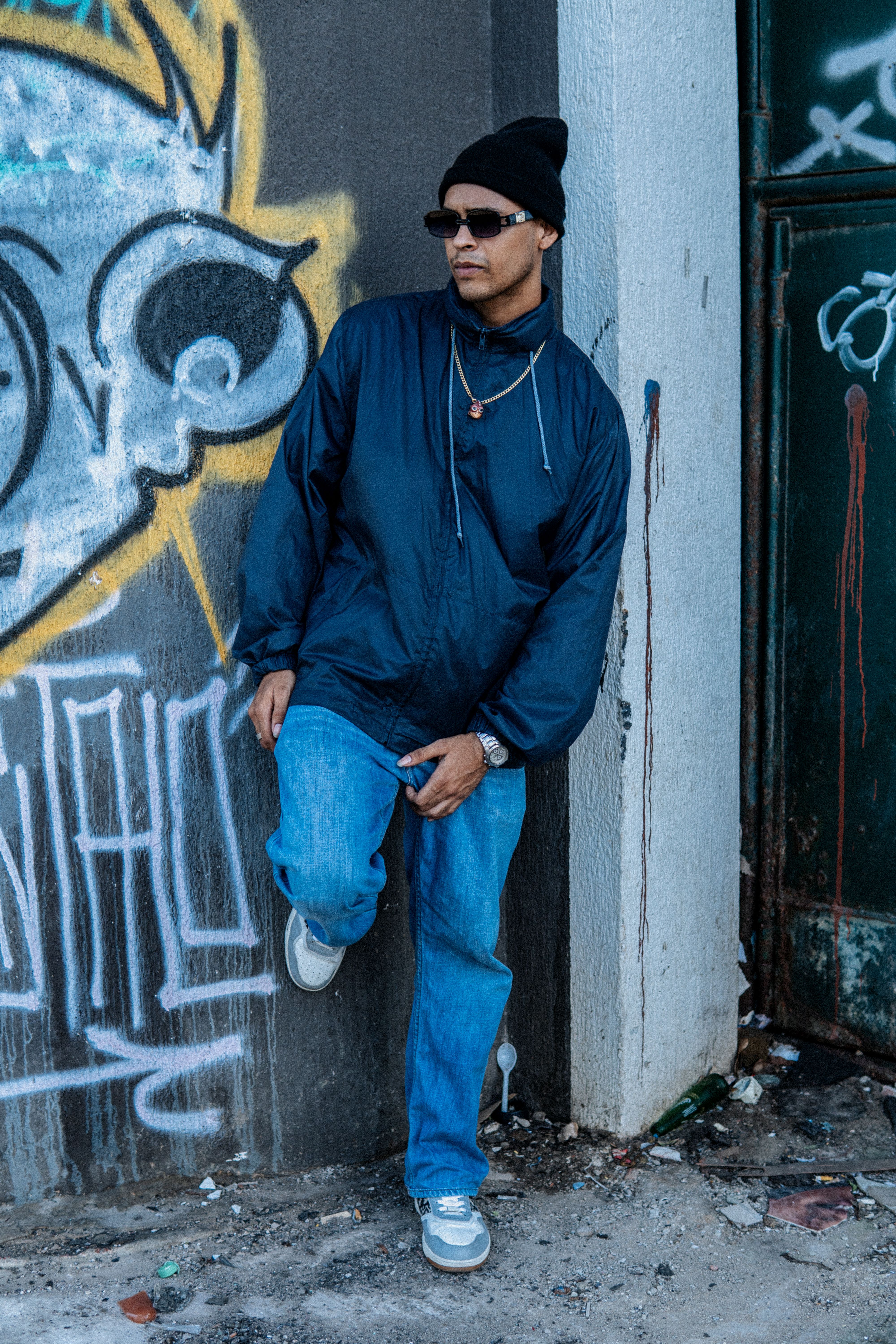 Man in Cap and Sunglasses Leaning on Wall · Free Stock Photo