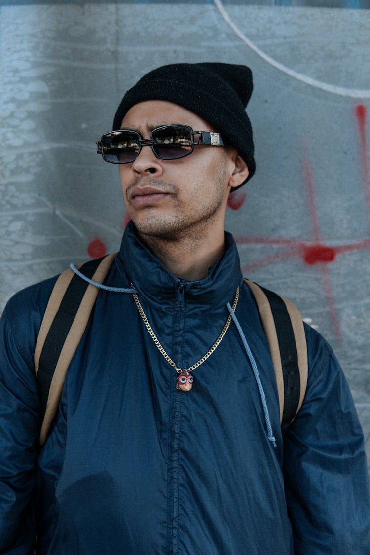 Portrait Of Man In Black Jacket, Cap And With Sunglasses