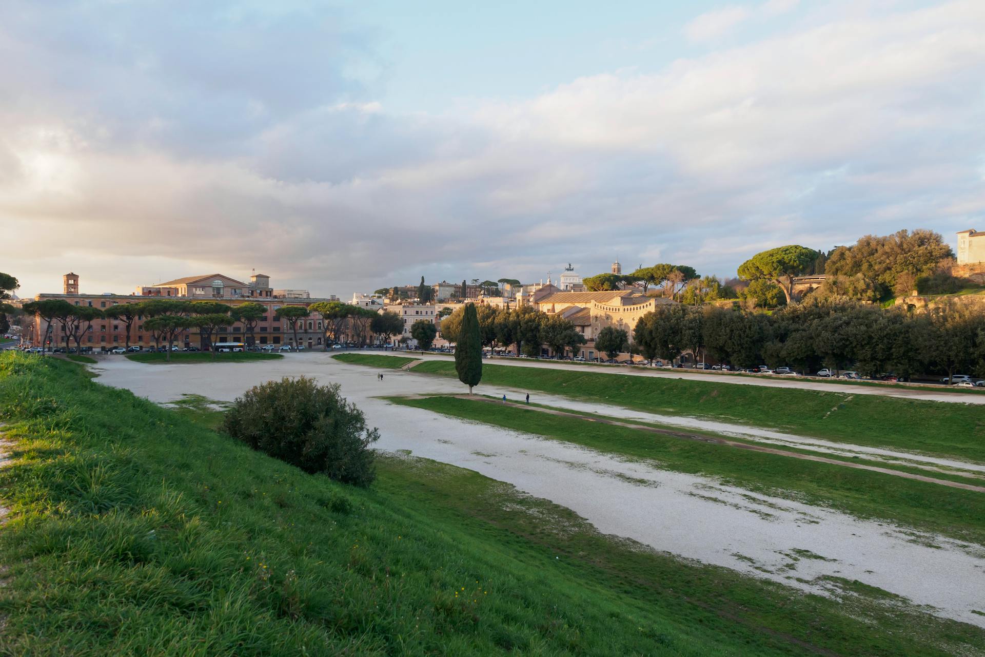 Beautiful landscape of Circus Maximus in Rome with lush greenery and a historic backdrop.