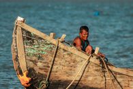 Woman in Black Bikini Sitting on Brown Wooden Boat