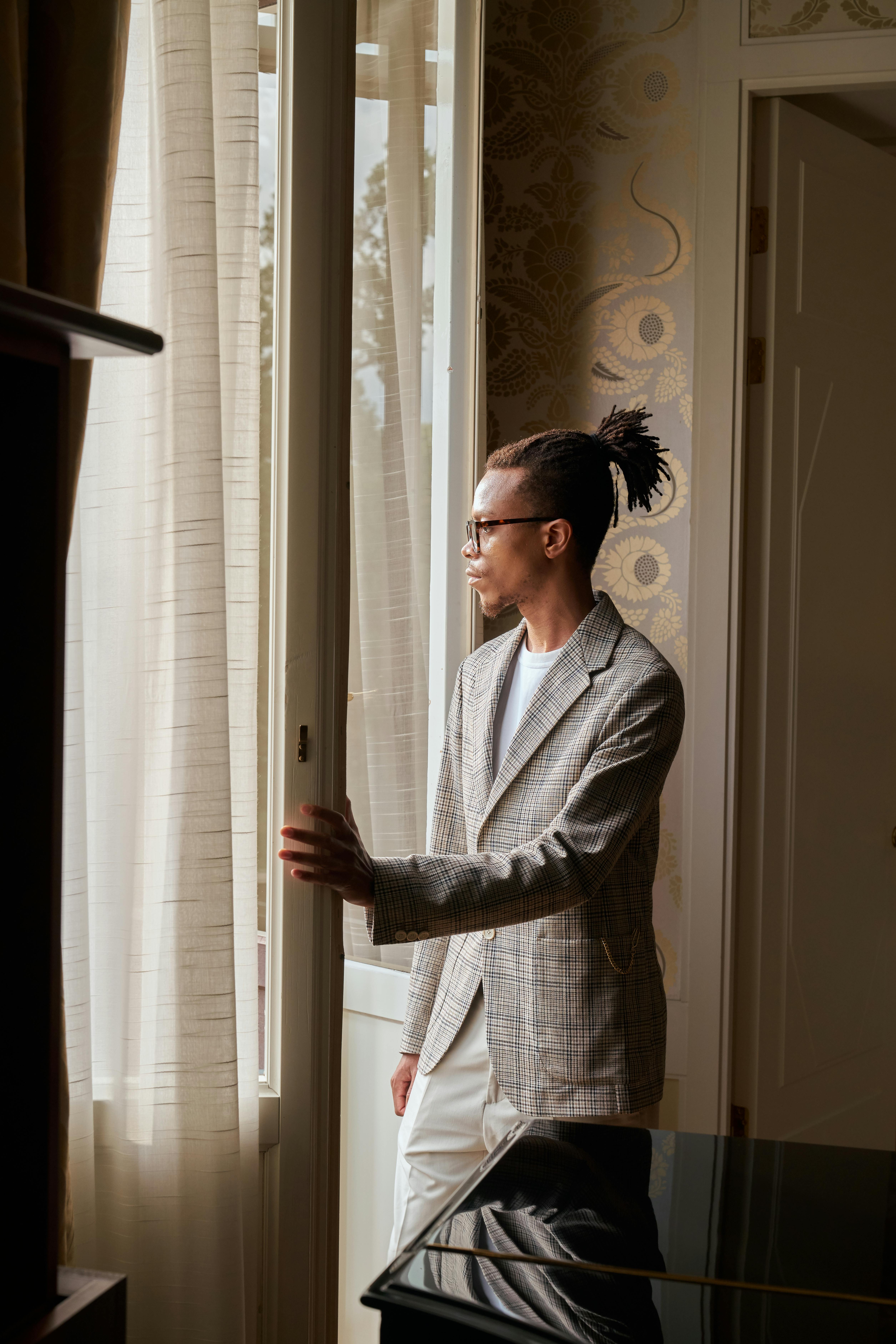 man in suit looking through window