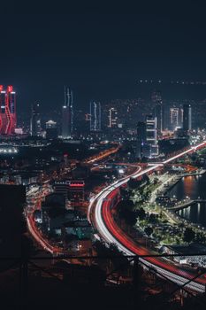 Stunning nighttime cityscape of İzmir featuring skyscrapers and light trails from traffic.