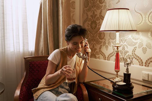 Woman Talking on Phone and Holding Glass