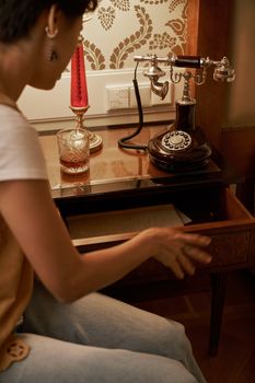 A cozy home setting featuring a vintage rotary phone and stylish decor on a bedside table.