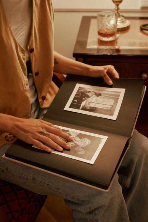 Free A person flips through a vintage photo album, reliving memories. Stock Photo