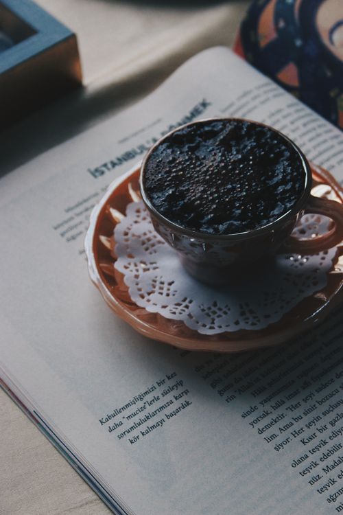 Free A close-up shot of a cup of Turkish coffee placed on an open magazine, creating a cozy reading atmosphere. Stock Photo