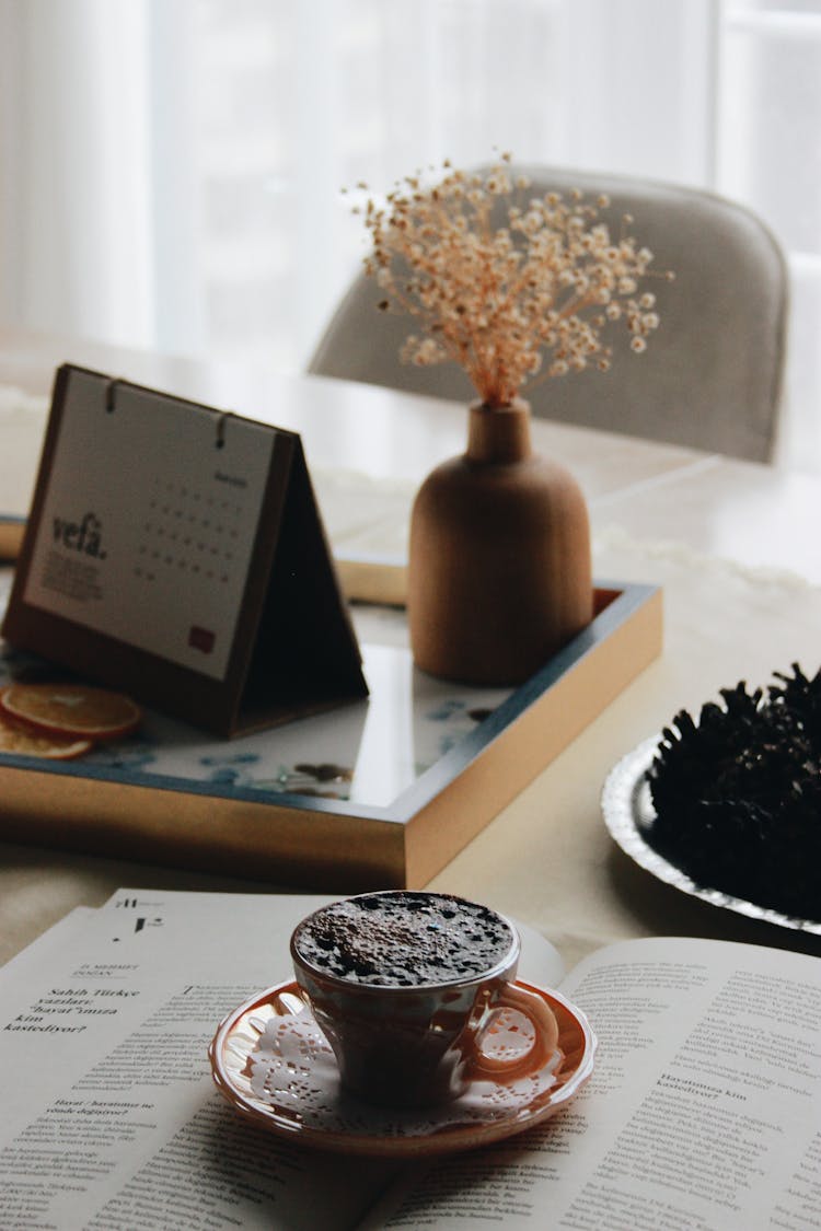 Coffee On Magazine And Calendar On Table
