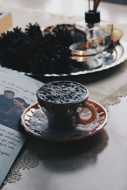 Free A Black Bubbly Drink in Orange Cup with Saucer Stock Photo