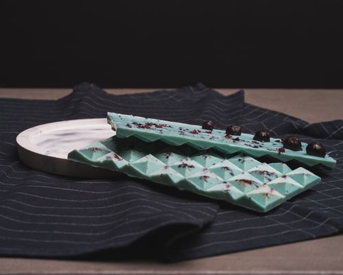 Free Elegant display of blue chocolate topped with blueberries on a fabric. Stock Photo