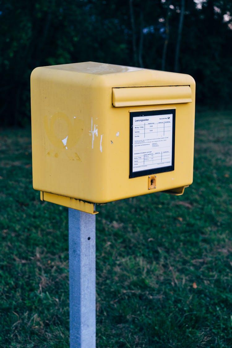 Yellow And White Mail Box On Green Grass