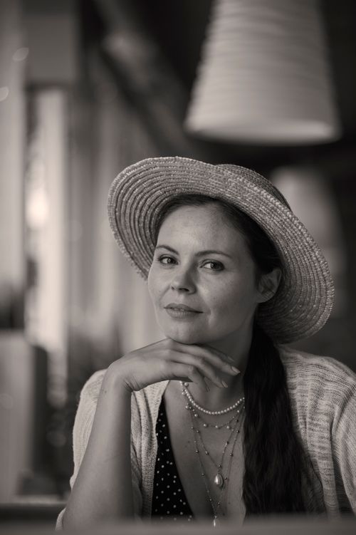 Free Black and white portrait of a woman in a straw hat, smiling indoors. Stock Photo