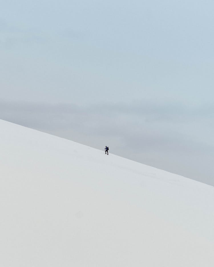 Man Climbing Mountain In Winter