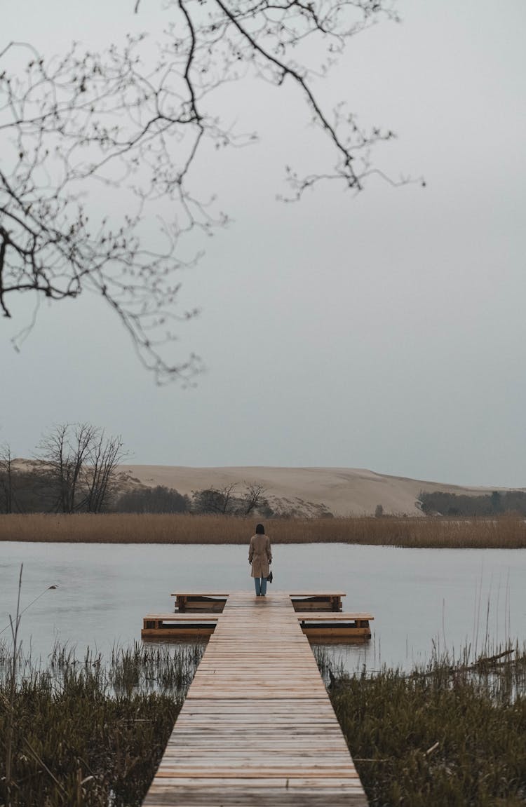 Distant Woman In Coat On Jetty