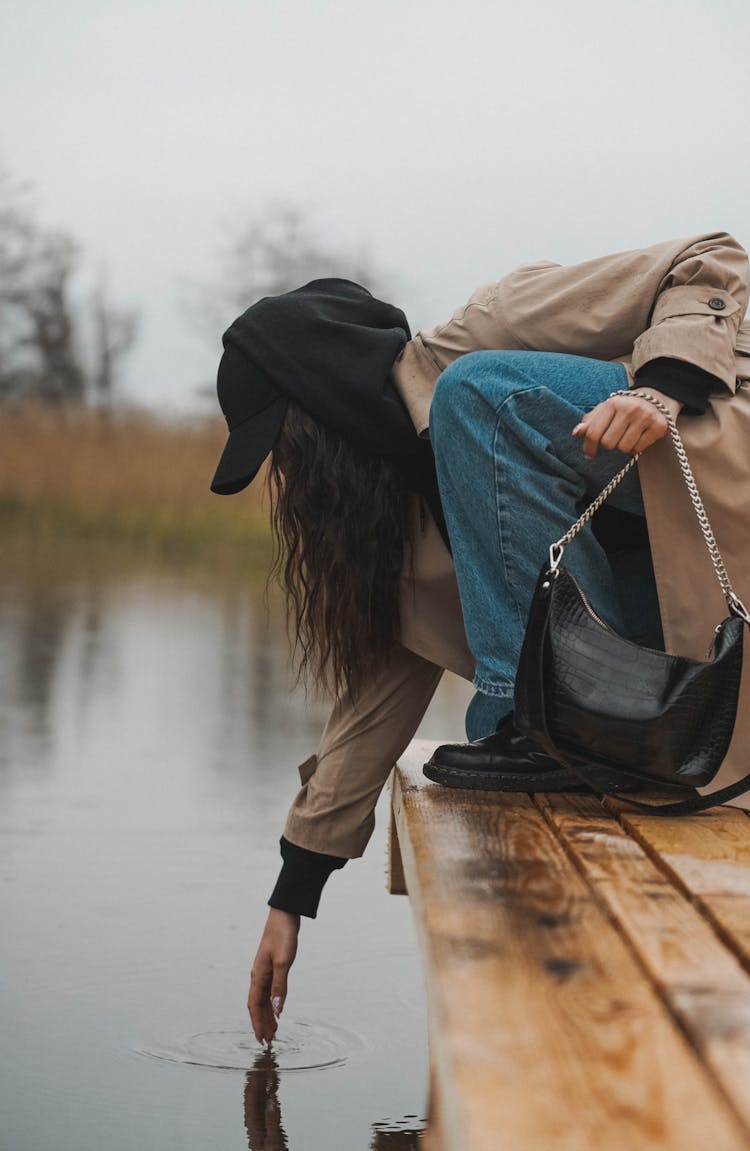 Woman Reaching Into Water