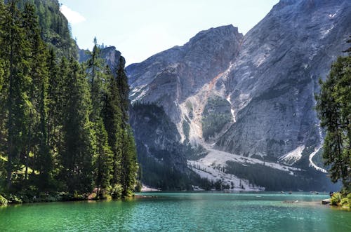 A Rocky Mountain by the Lake Surrounded by Green Trees