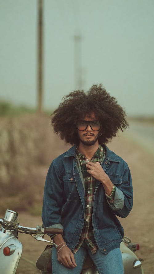 Man in Blue Denim Jacket Sitting on Scooter