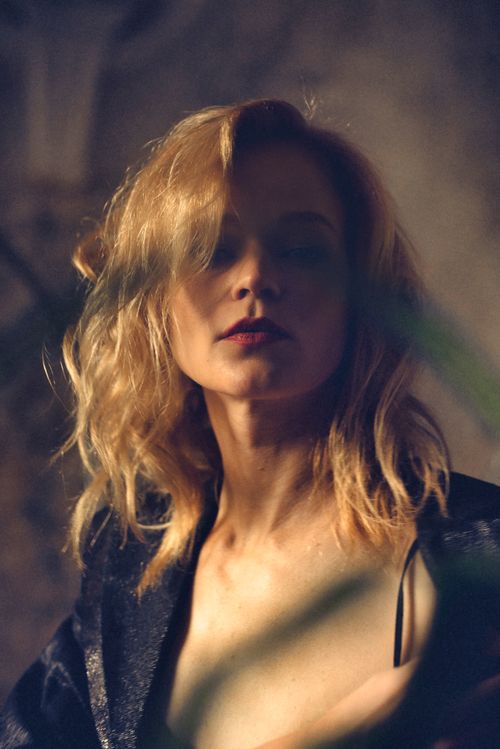 Free Striking portrait of a woman with blonde hair in a moody indoor setting. Stock Photo