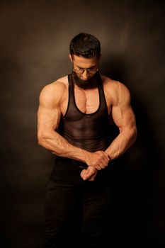 Strong and muscular man posing in gym wear, showcasing fitness and strength.