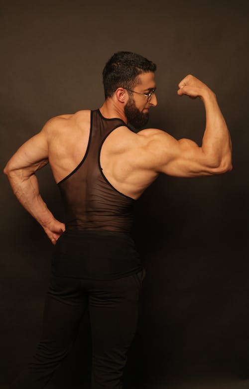 Free Back View of a Man Flexing his Muscles Stock Photo