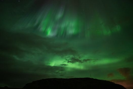 Captivating capture of the Aurora Borealis lighting up the night sky with vibrant shades of green.