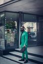 A Man in the Green Suit holding Wristlet Bag