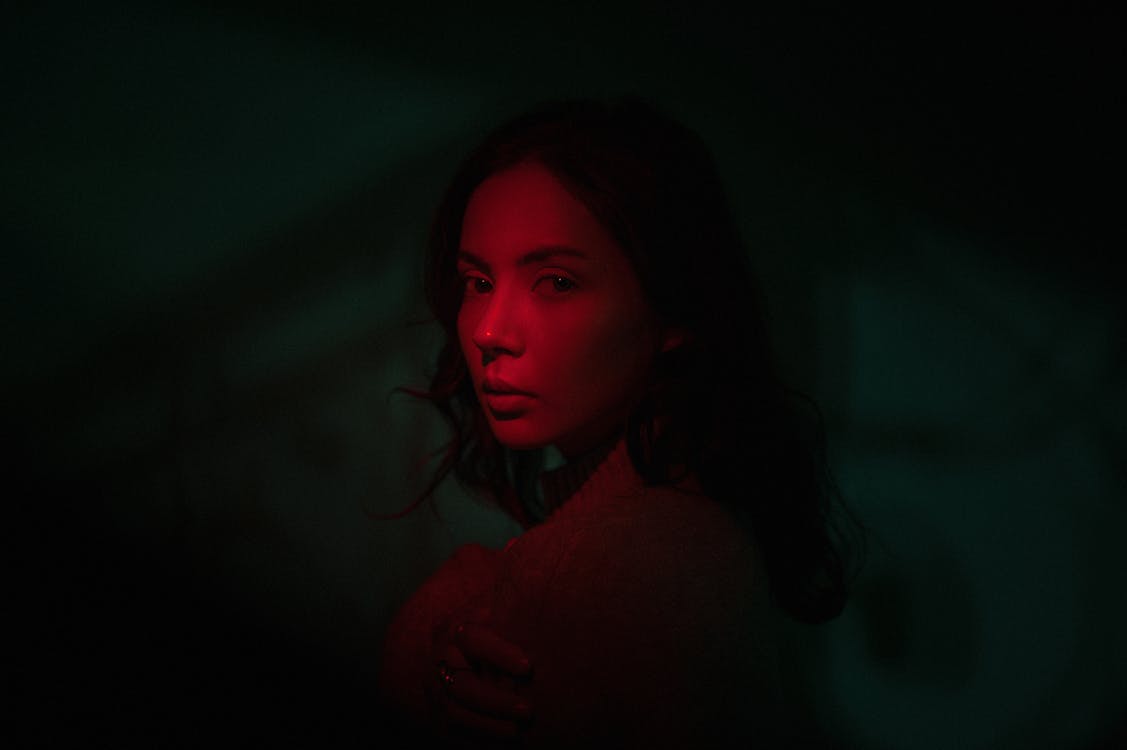 Woman in Dark With Red Light on her Face · Free Stock Photo