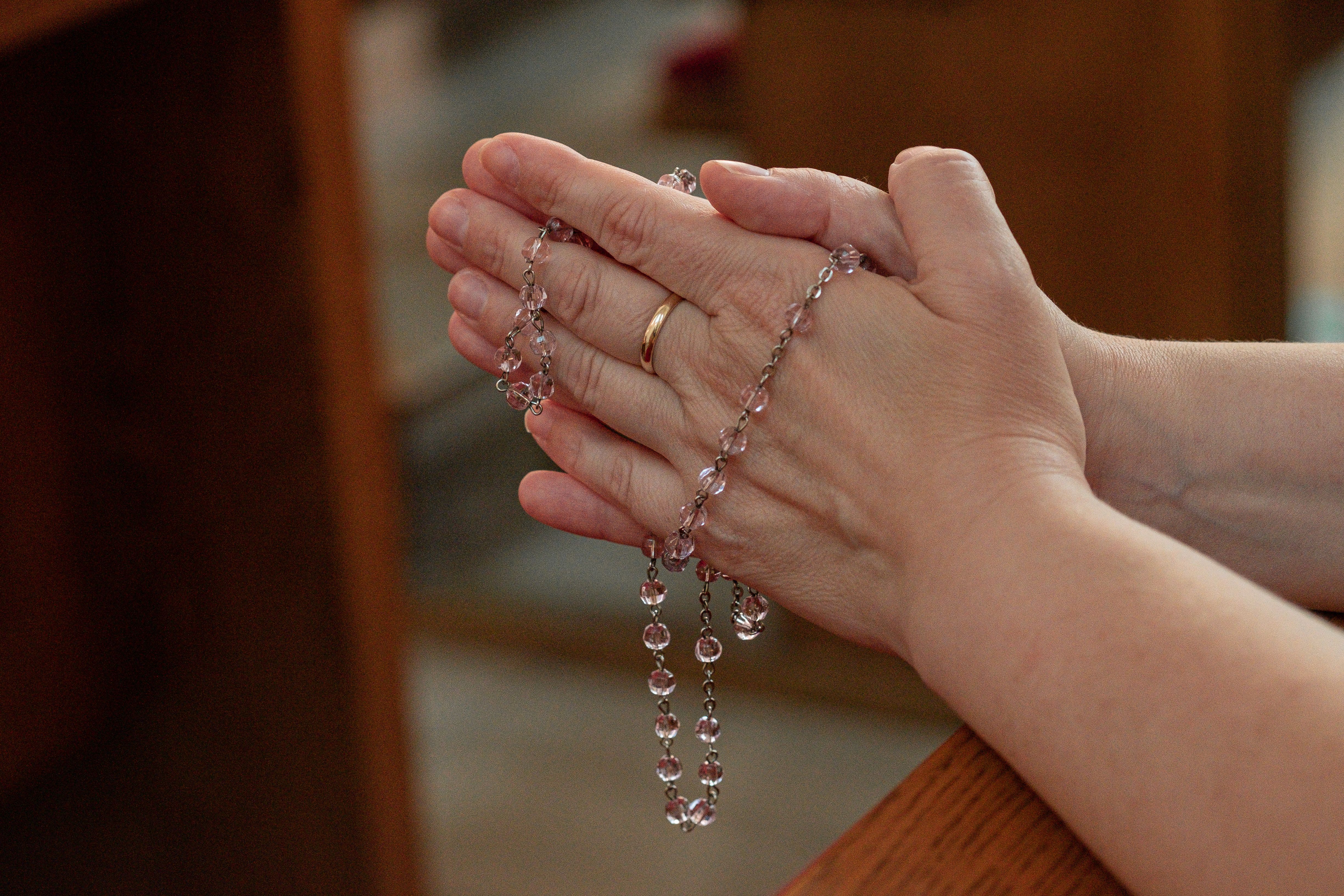 Orthodox prayer rope wrapped around a hand, soft focus, warm lighting