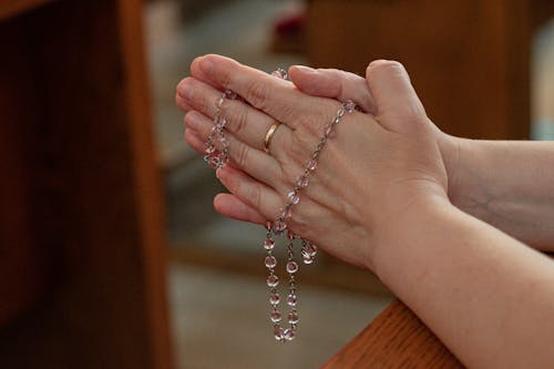Free A Person Praying using Rosary Stock Photo