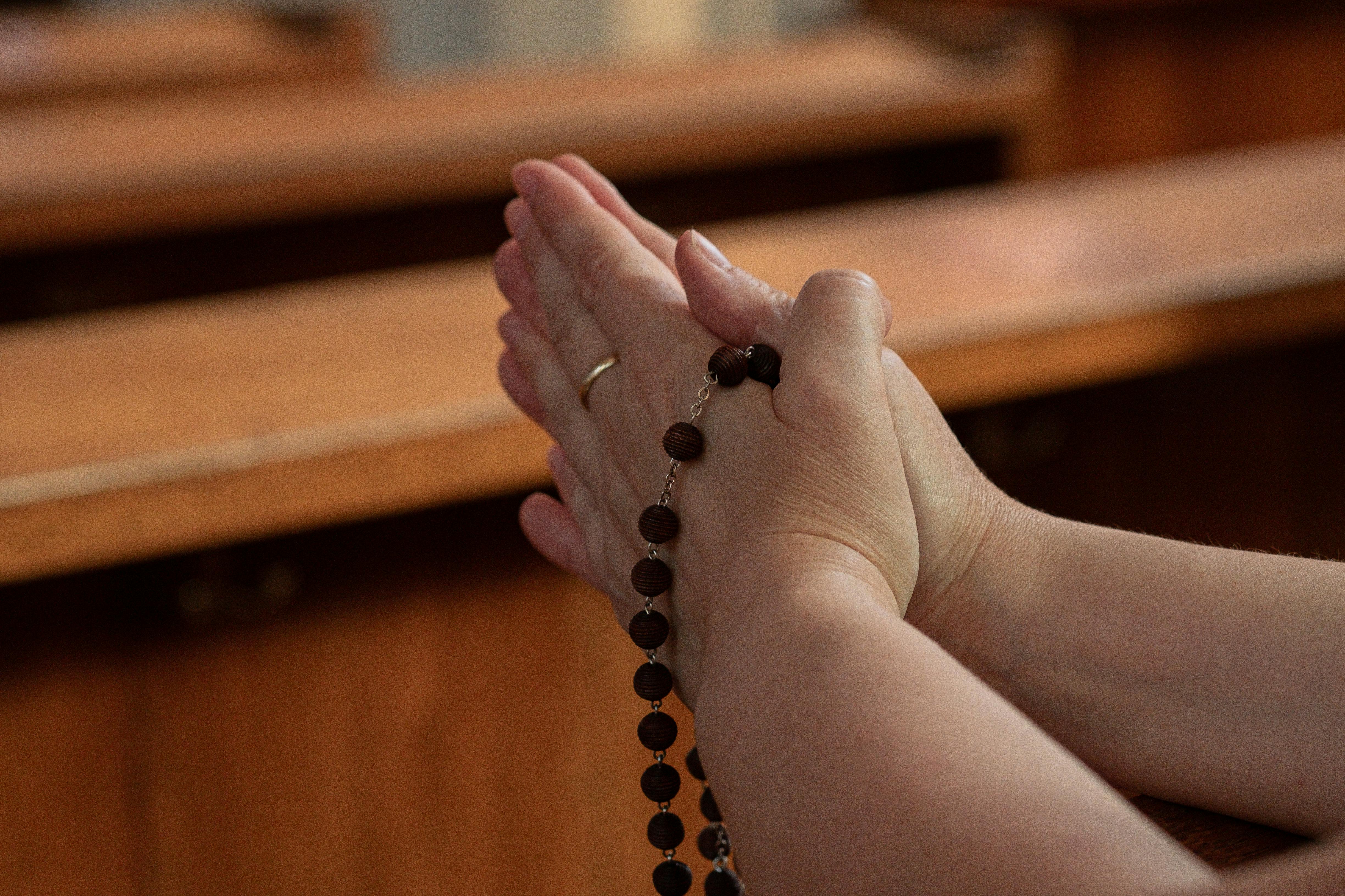 Mãos a rezar com um terço - o poder da oração com contas abençoadas
