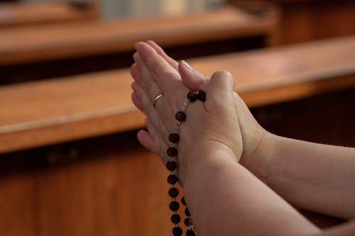 Free A Praying Hands using Rosary Stock Photo