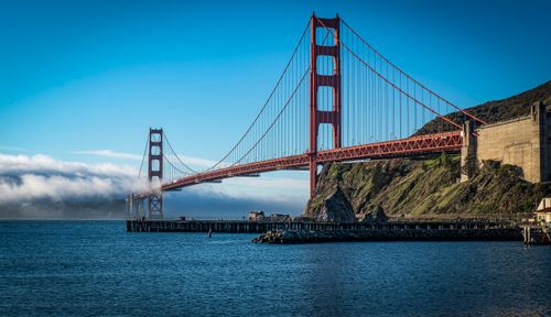 Free Iconic Golden Gate Bridge stretching over the bay under a clear blue sky in San Francisco. Stock Photo