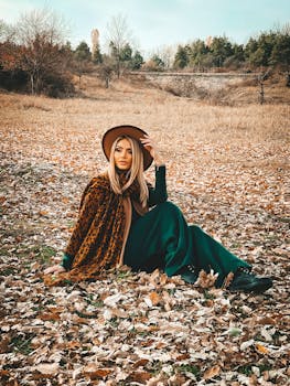 一位时尚女士坐在落叶上，穿着豹纹外套，戴着帽子