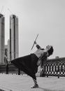 Queer Girl in Long Skirt and Striped Tights Leaning Back on One Leg
