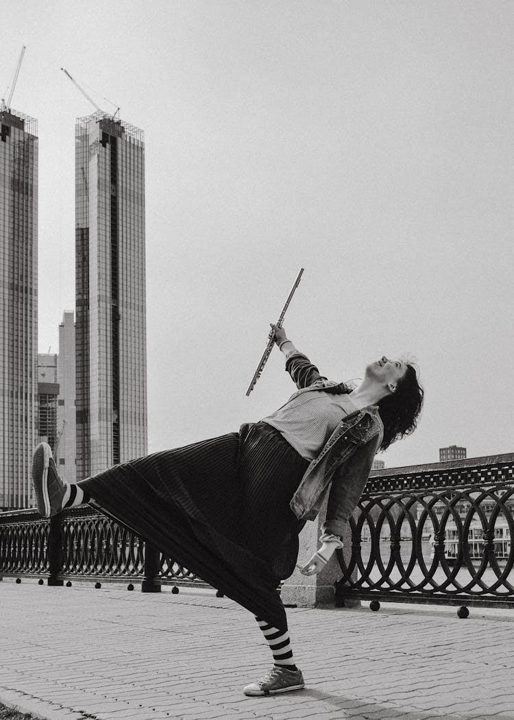 Queer Girl In Long Skirt And Striped Tights Leaning Back On One Leg