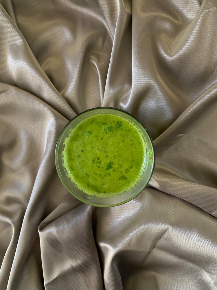 Green Juice In Glass On Silk Fabric