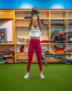 Fitness enthusiast lifting a kettle bell indoors, showcasing strength and active lifestyle.