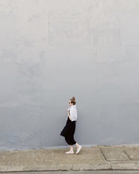 Woman Wearing Black Maxi Dress and Pair of White Flats Standing Beside Gray Wall