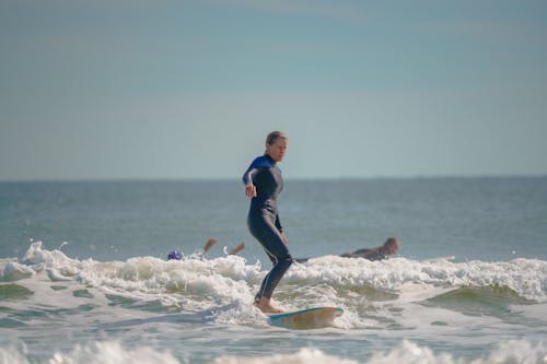 Безкоштовне стокове фото на тему «водний спорт, гідрокостюм, дошка для серфінгу»