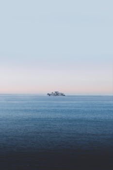 Serene view of a cruise ship on the peaceful waters of Bichvinta at sunset.
