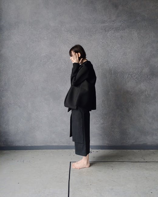 Woman in Black Gi Standing Beside Gray Wall