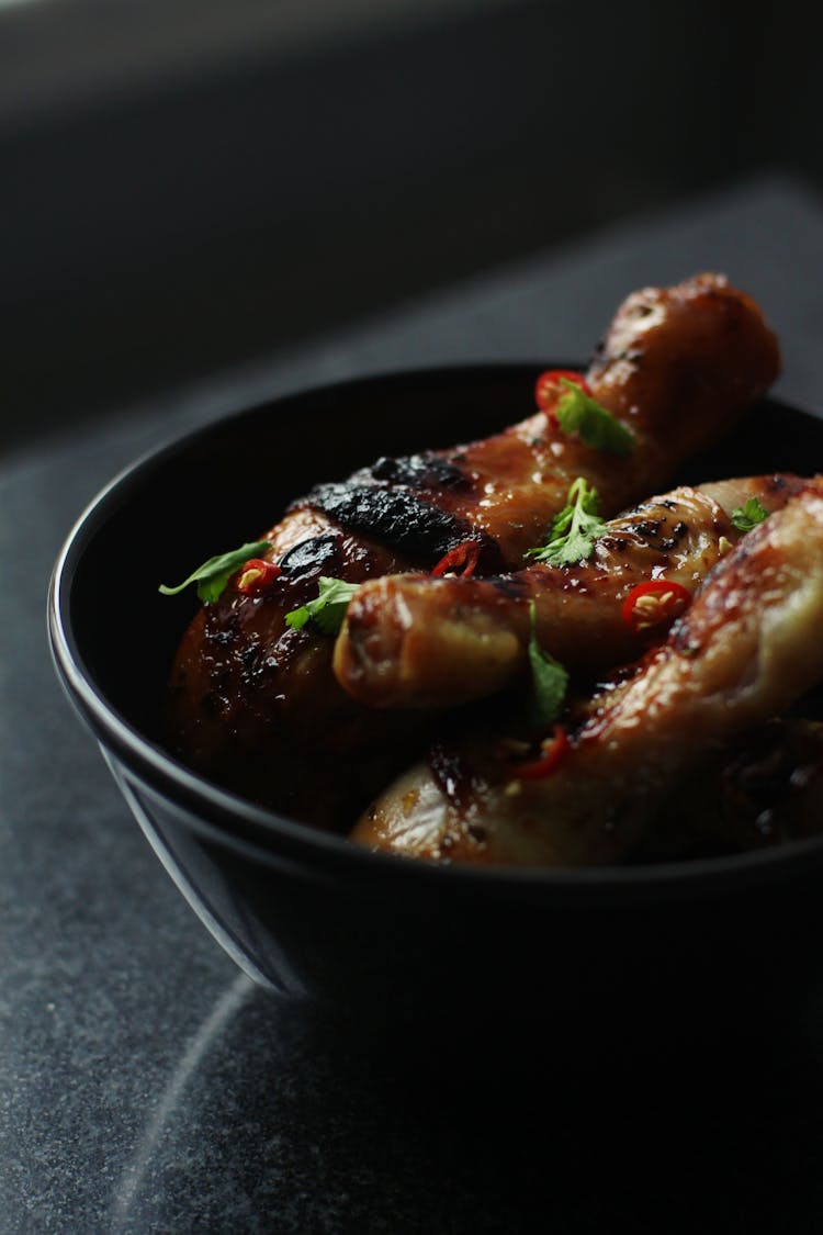 Roasted Chicken Legs Served With Parsley Leaves In Ceramic Bowl