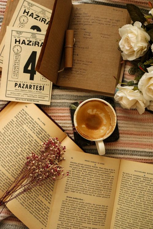 Free Warm flat lay featuring an open journal, coffee cup, and flowers for a cozy vibe. Stock Photo