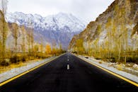 秋天的树木和白雪皑皑的山脉环绕着罕萨山谷美丽的道路