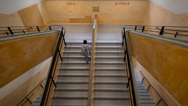 A Woman Walking while Going Up on Stairs